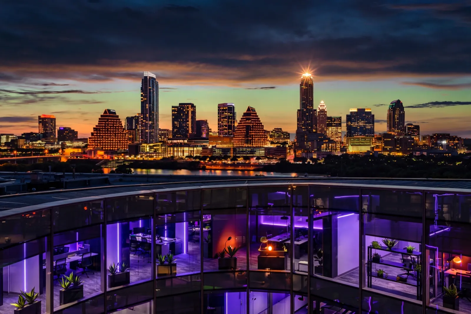 The Austin Texas skyline at dusk with a star-lit tower silhouette and violet-lit modern glass building in the foreground, ill